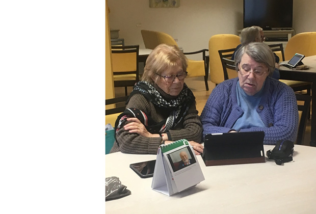 Deux résidentes qui manipulent une tablette Ardoiz.
