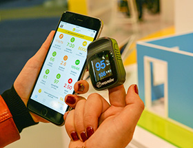 A woman using a connected object in tandem with an application like Digiposte + designed by La Poste