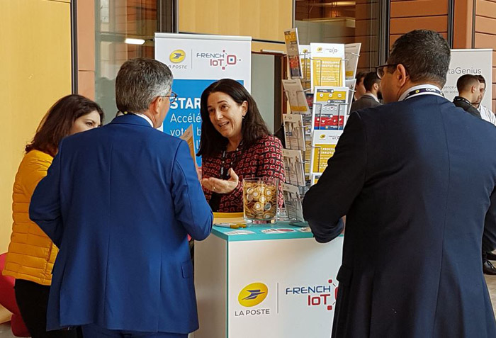 Photo du stand de La Poste au Sido 2019, avec Vanessa Chocteau expliquant à un visiteur le programme d’accélération French IoT