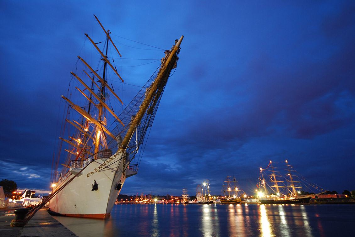 Photo de nuit avec plusieurs trois-mâts à quai lors de la précédente édition de l’Armada.