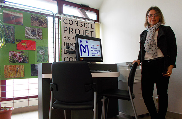 Photo avec un îlot numérique (maison de services au public affiché sur l'écran de l'ordinateur) et Sarah Lambérioux, gérante de l’agence.