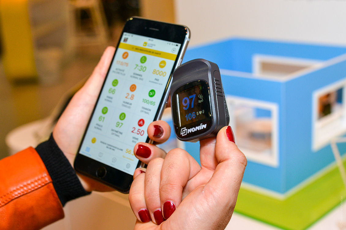 Une femme utilisant un objet connecté de La Poste en complément des applications la Poste comme Digiposte +