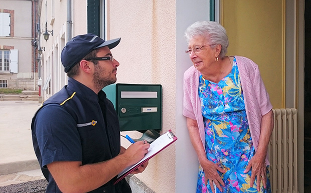 La photo d'une senior répondant au questionnaire que lui soumet un facteur