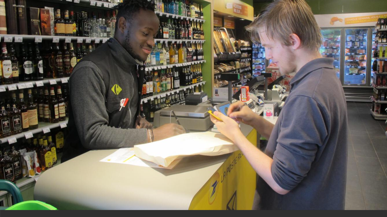A customer using the La Poste pick-up point in the Tourcoing Carrefour City